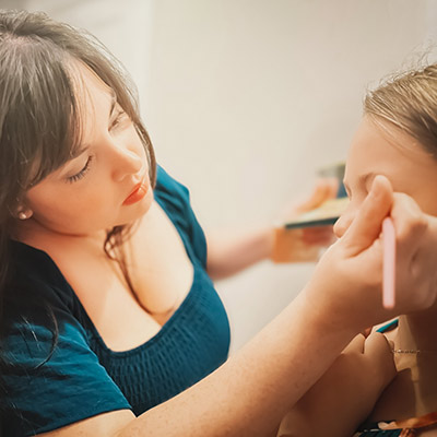 Erin applying makeup to a bride